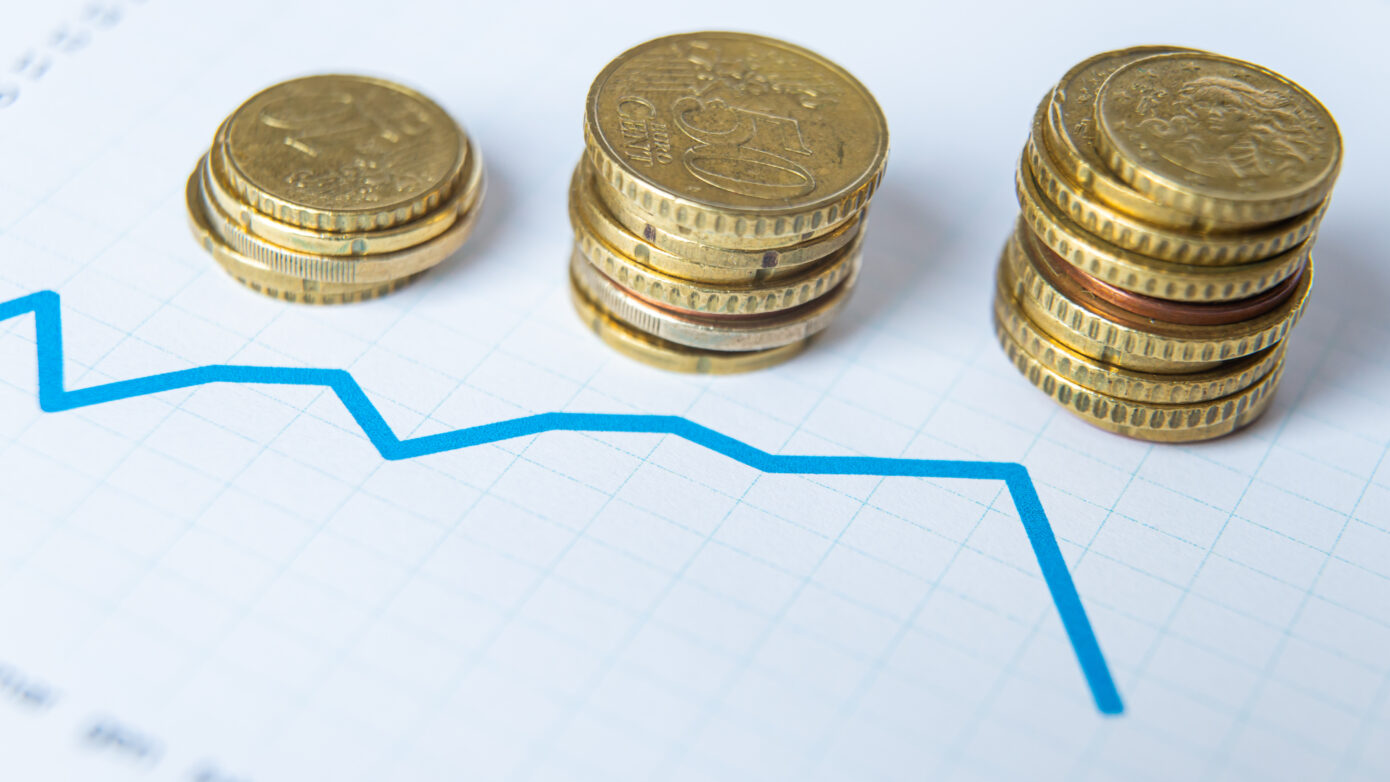 Three stacks of cent coins with a graph showing loss of capital