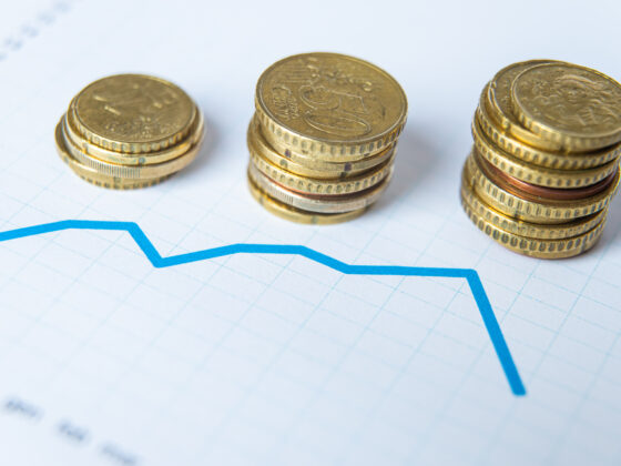 Three stacks of cent coins with a graph showing loss of capital