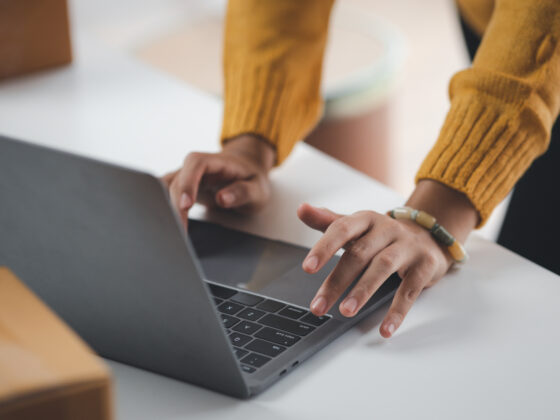 A business owner operates a laptop computer to file company documents